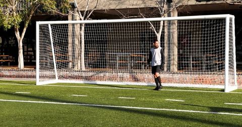 Soccer Player Standing by Goalpost on Sunny Day - Download Free Stock Images Pikwizard.com