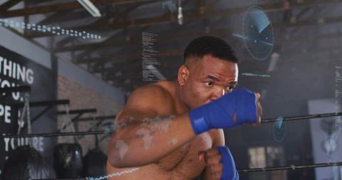 Black boxer training in gritty gym, punching with blue hand wraps and high-tech hud