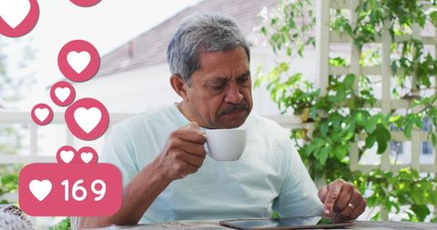 Senior Man Engaging with Social Media While Enjoying Coffee Outdoors