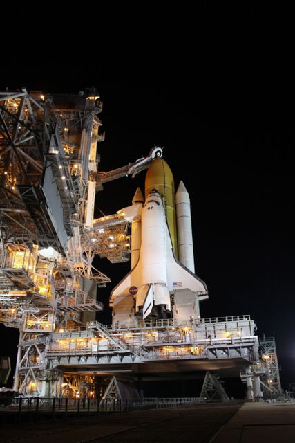 Image depicting NASA's Space Shuttle Discovery at Launch Pad 39A at Kennedy Space Center. The oxygen vent hood is positioned above the shuttle's external fuel tank after the rollback of the rotating service structure. This photo can be used in articles about space exploration, NASA missions, or engineering marvels. Ideal for educational purposes, science presentations, and news media usage related to historic space missions.