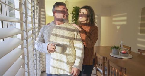 Middle-Aged Couple Enjoying Sunlit Moments in Cozy Dining Room