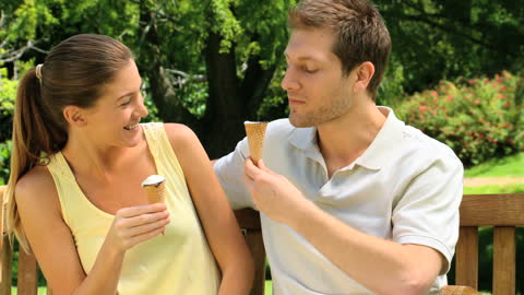 Happy Couple Enjoying Ice Cream Together in Park