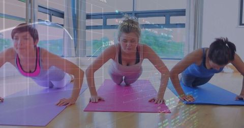 Women Practicing Plank Pose in Modern Fitness Studio