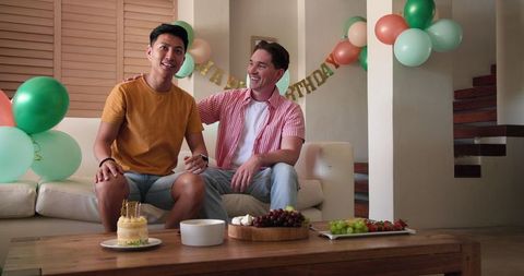Gay Couple Celebrating Birthday with Snacks at Home