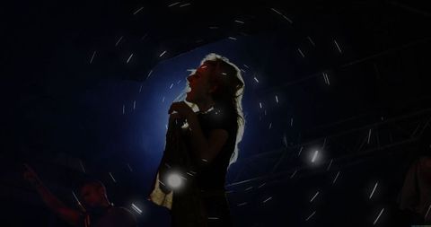 Vibrant Backlit Live Performance of Female Singer on Stage