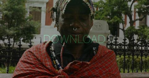 Man in cultural attire sitting in park with heritage elements