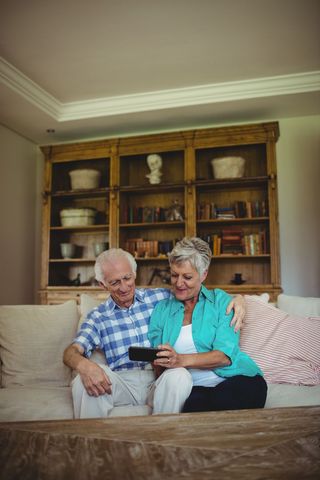 Senior Couple Enjoying Mobile Technology in Cozy Living Room - Download Free Stock Images Pikwizard.com
