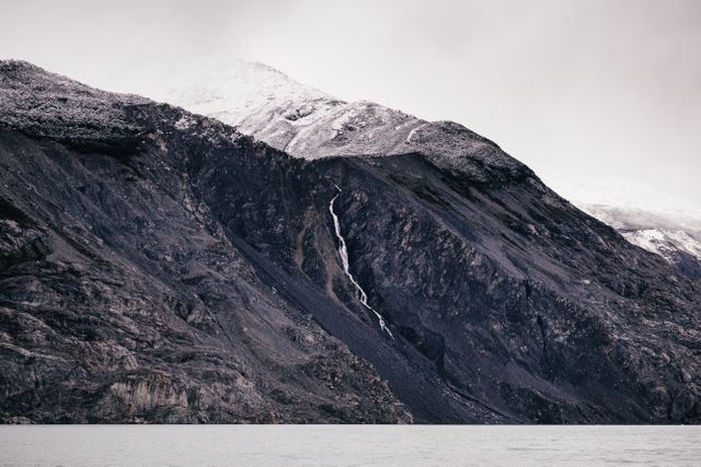 Snow-capped Mountain with Waterfall Cascading Down Rocky Slope - Download Free Stock Photos Pikwizard.com