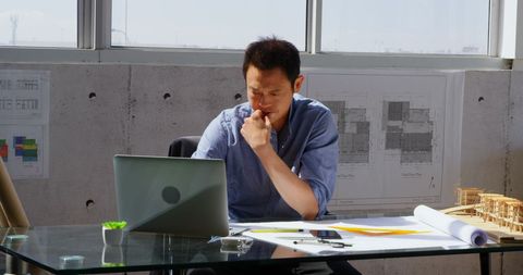 Focused Asian Architect Working on Laptop in Modern Office - Download Free Stock Images Pikwizard.com