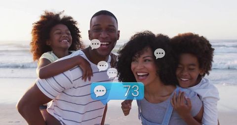 Smiling family laughing and enjoying piggyback rides on beach with chat notification 73