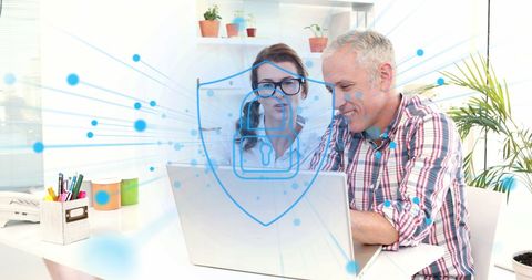 Business Team Discussing Cybersecurity Over Laptop with Shield Graphic
