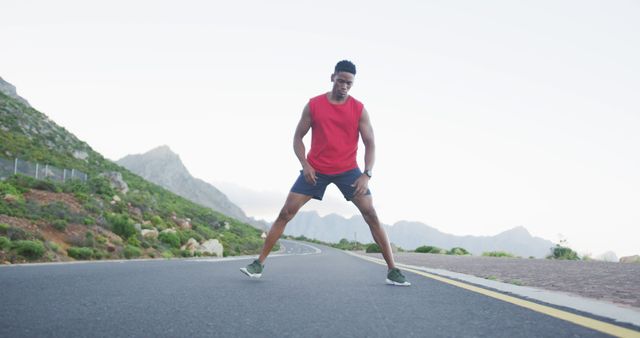 Athletic Man Stretching on Road in Mountainous Area - Download Free Stock Images Pikwizard.com