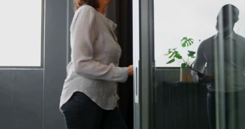 Businesswoman entering office through sliding glass door