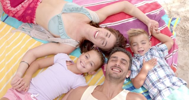 Happy Family Relaxing on Beach Towels Enjoying Summer - Download Free Stock Images Pikwizard.com