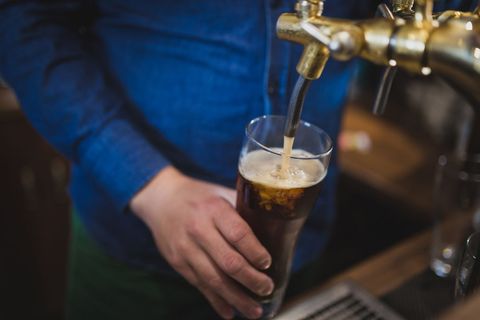 Bartender Pouring Dark Beer from Tap into Glass
