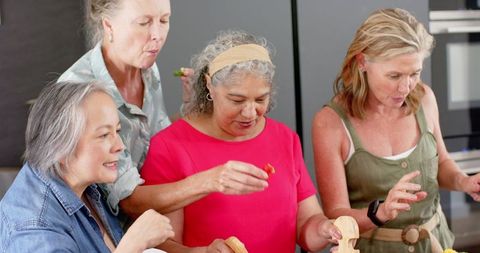 Senior Friends Joyfully Preparing Meal Together at Home