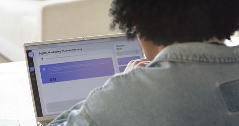 African american man working on laptop reviewing digital marketing plan and branding interface