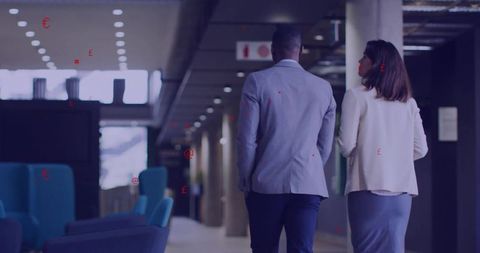 Business professionals walking in modern corporate corridor with lounge seating, natural light