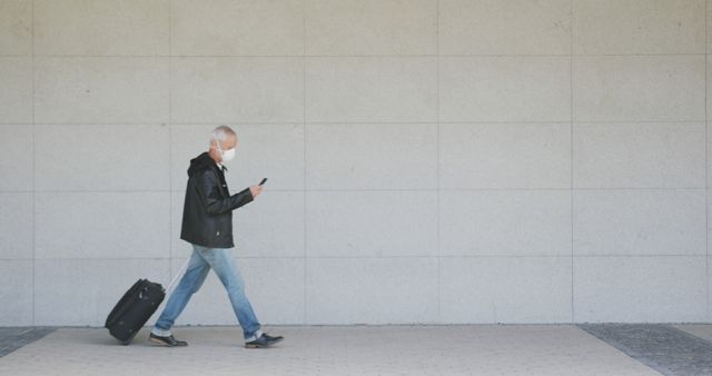 Elderly Man with Suitcase Walking While Checking Phone - Download Free Stock Images Pikwizard.com