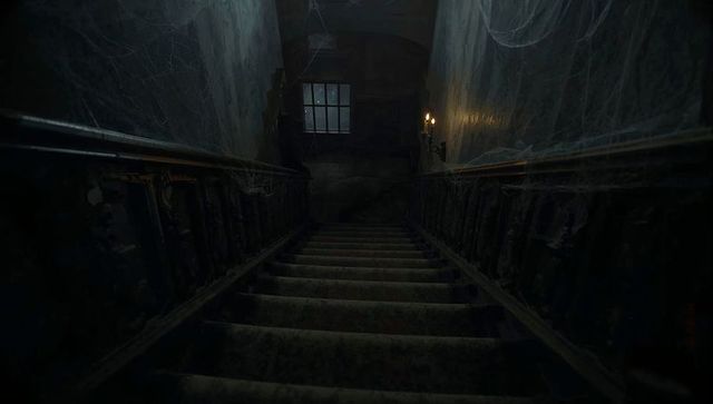Descending dusty mansion staircase with candlelit cobwebs and gothic decay