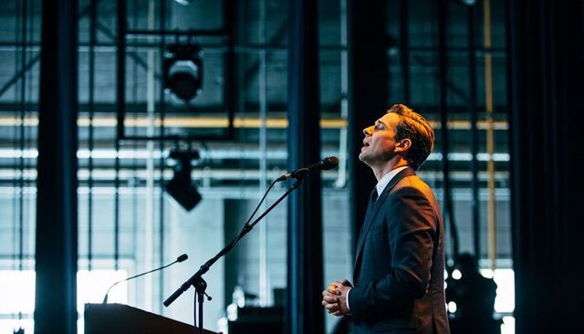 Business leader delivering keynote speech at conference stage with professional poise