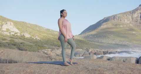 Woman Exploring Yoga Amid Stunning Oceanic Cliffside Views