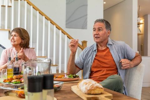 Senior couple enjoying meal at home in dining room