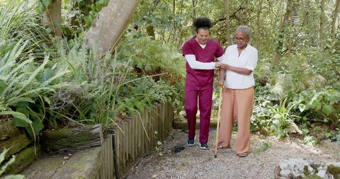 Healthcare Worker Supporting Senior Woman Outdoors