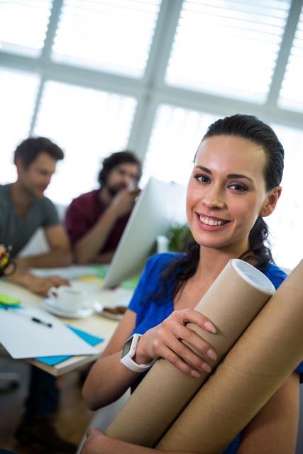 Confident Female Graphic Designer Holding Chart Holder in Modern Office - Download Free Stock Images Pikwizard.com