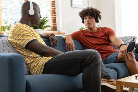 Diverse male podcast hosts recording conversation at home