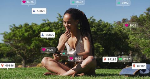 Woman Engaging with Social Media Outdoors in Lively Urban Park