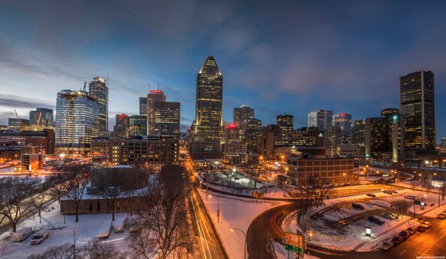 Snow-covered streets of Montreal at twilight with skyscrapers illuminated against the evening sky, suitable for urban planning, travel marketing, winter seasonal promotions, or brochures. Perfect for showcasing the vibrant energy of a wintery metropolitan city.