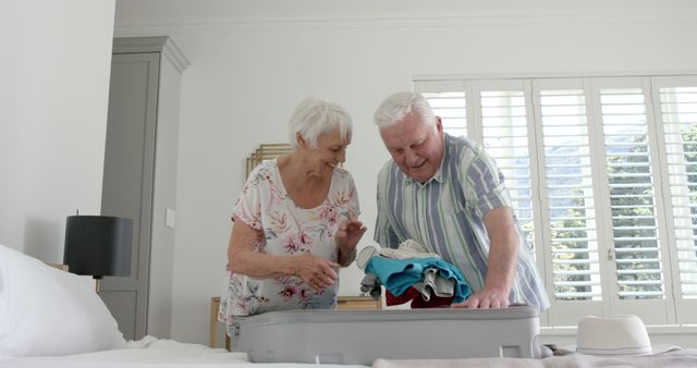 Happy Senior Couple Packing Suitcase for Vacation in Bedroom - Download Free Stock Images Pikwizard.com