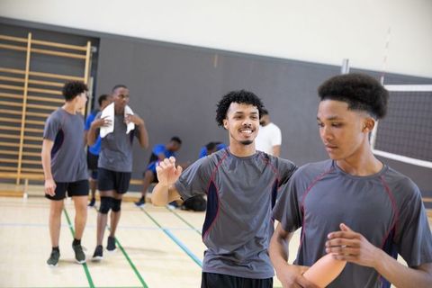 African american high school male teen athletes warming up for volleyball practice
