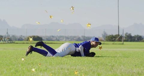 Baseball player lying on field surrounded by celebratory stars