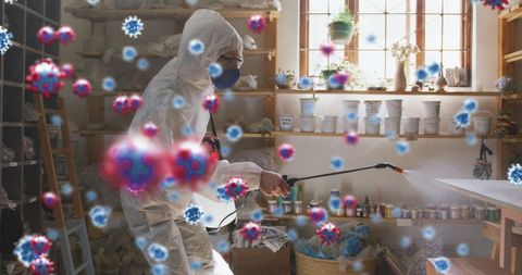 Worker in PPE Disinfecting Workshop Amid COVID-19 Pandemic