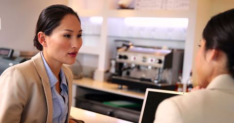 Businesswomen Having Informal Meeting at Coffee Shop Counter