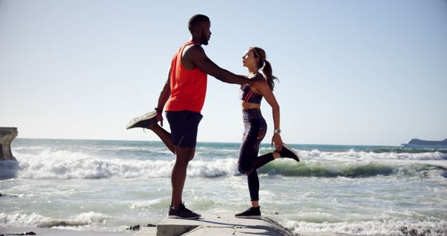 Couple Stretching Together by Ocean Shoreline During Sunset - Download Free Stock Images Pikwizard.com