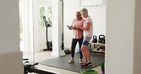Elderly Couple Enjoying Workout and Tablet in Home Gym