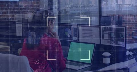 Businesswoman Analyzing Data on Multiple Screens in Modern Office