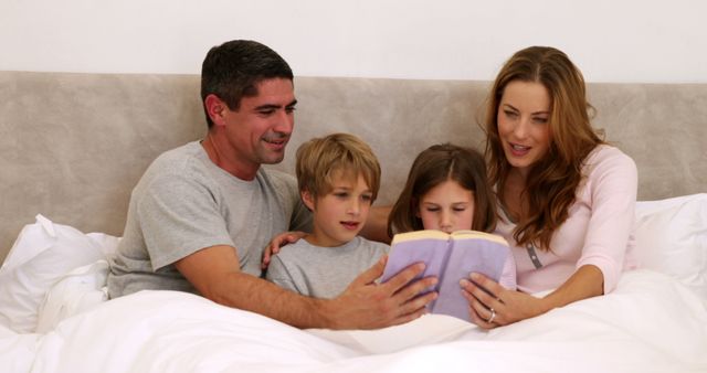 Happy Family Reading a Book in Bed Together - Download Free Stock Images Pikwizard.com
