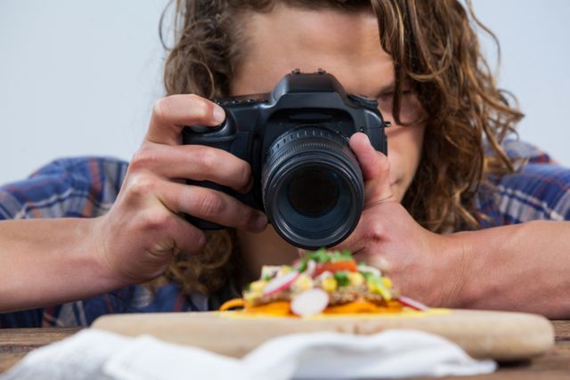 Close-up of photographer clicking a picture of food using digital camera