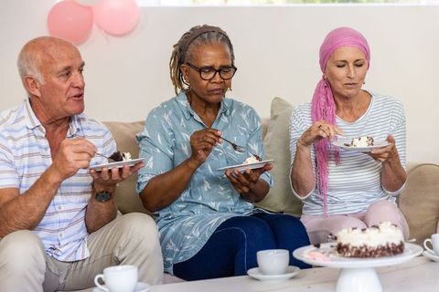 Senior Friends Enjoying Cake and Tea at Home Gathering