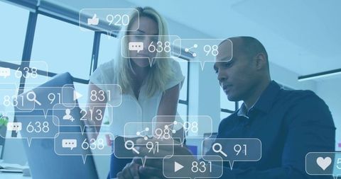 Marketing team analyzing social media metrics on laptop and smartphone for strategy