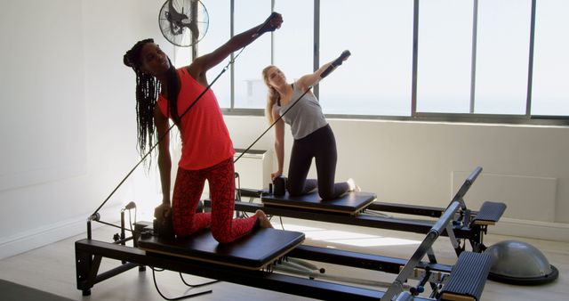 Two Women Doing Pilates Workout on Reformer Machines - Download Free Stock Images Pikwizard.com