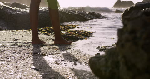 Barefoot Exploring on Sandy Coastline with Waves