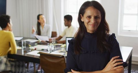 Confident Businesswoman Leading Diverse Meeting in Modern Office