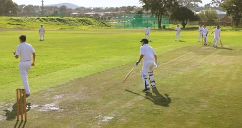 Male cricketer standing on suburban cricket ground during match