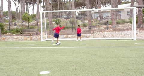 Boys Practicing Soccer Drills on Synthetic Field Near Goalposts