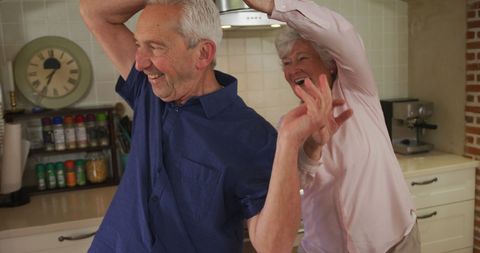 Joyful Senior Couple Dancing in Kitchen Together